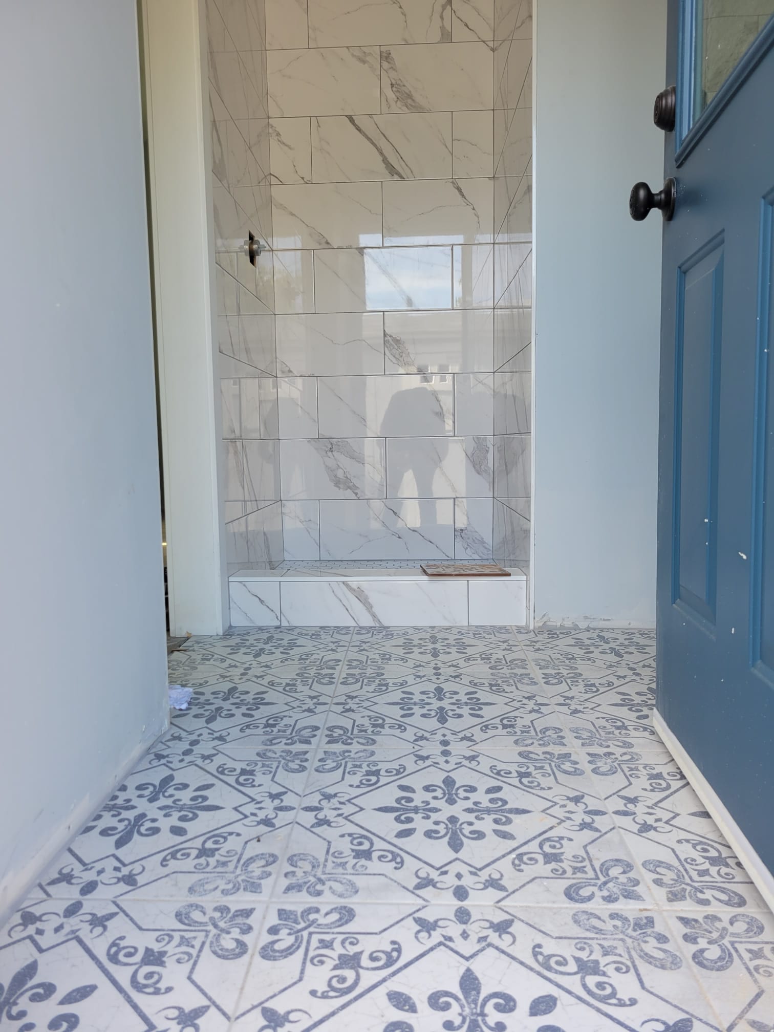47th St. ADU bathroom entry with patterned floor tile and marble-look shower tile