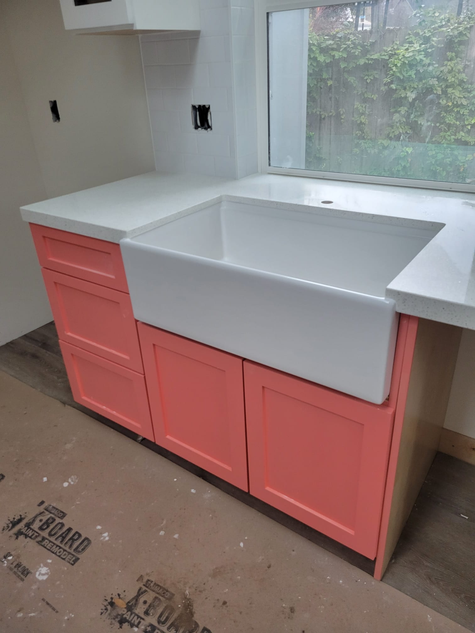 48th St. ADU kitchen with coral cabinets and a farmhouse sink