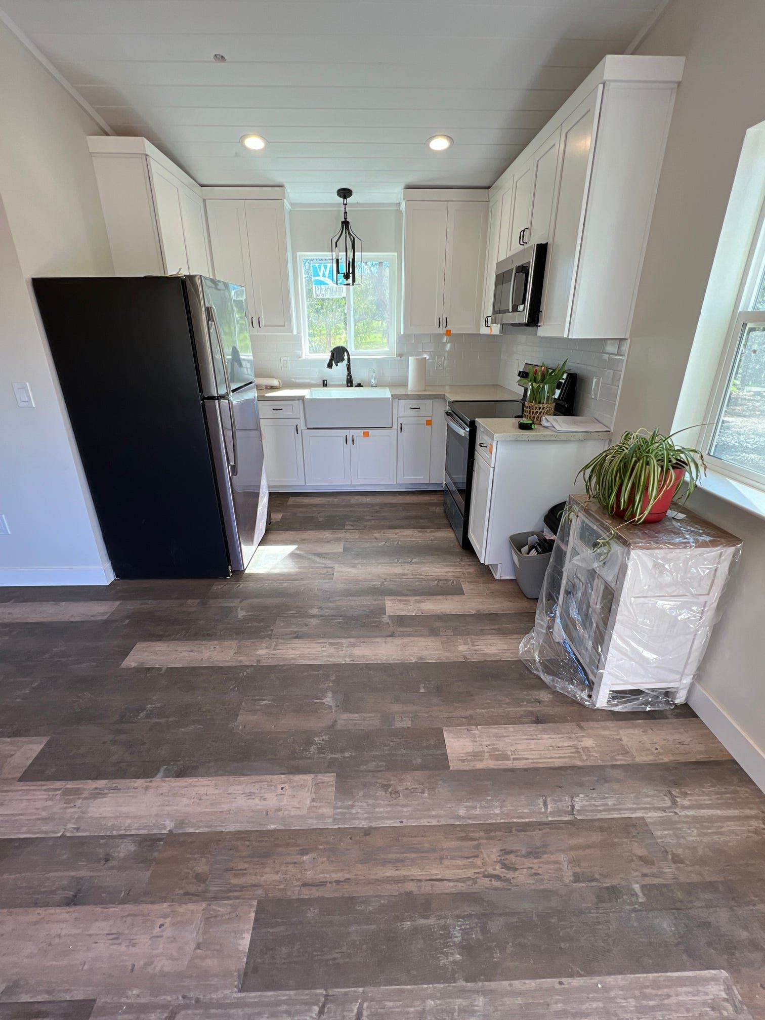 ADU kitchen with black appliances and wood-look flooring
