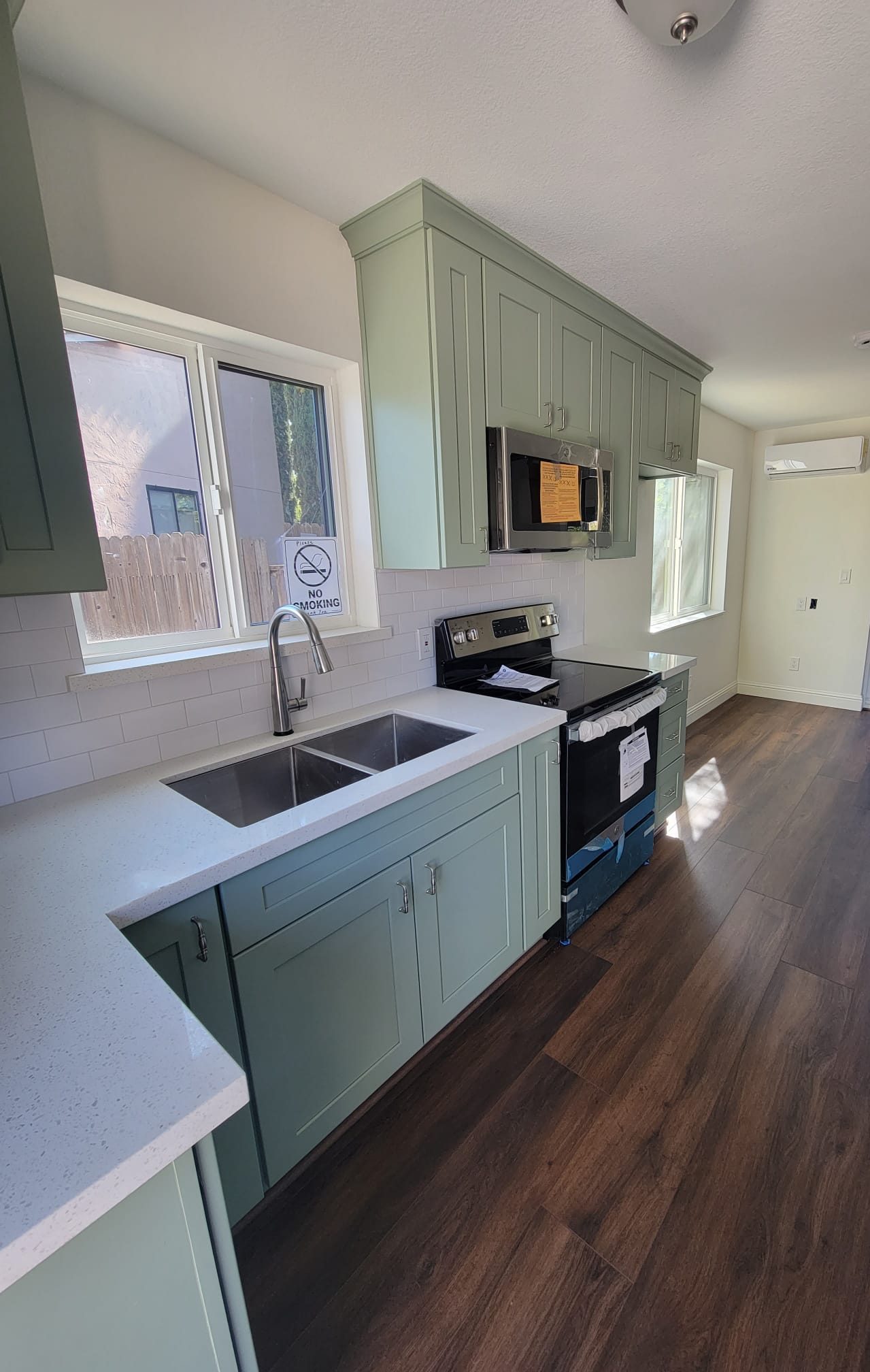 ADU kitchen with sage green cabinets and stainless appliances