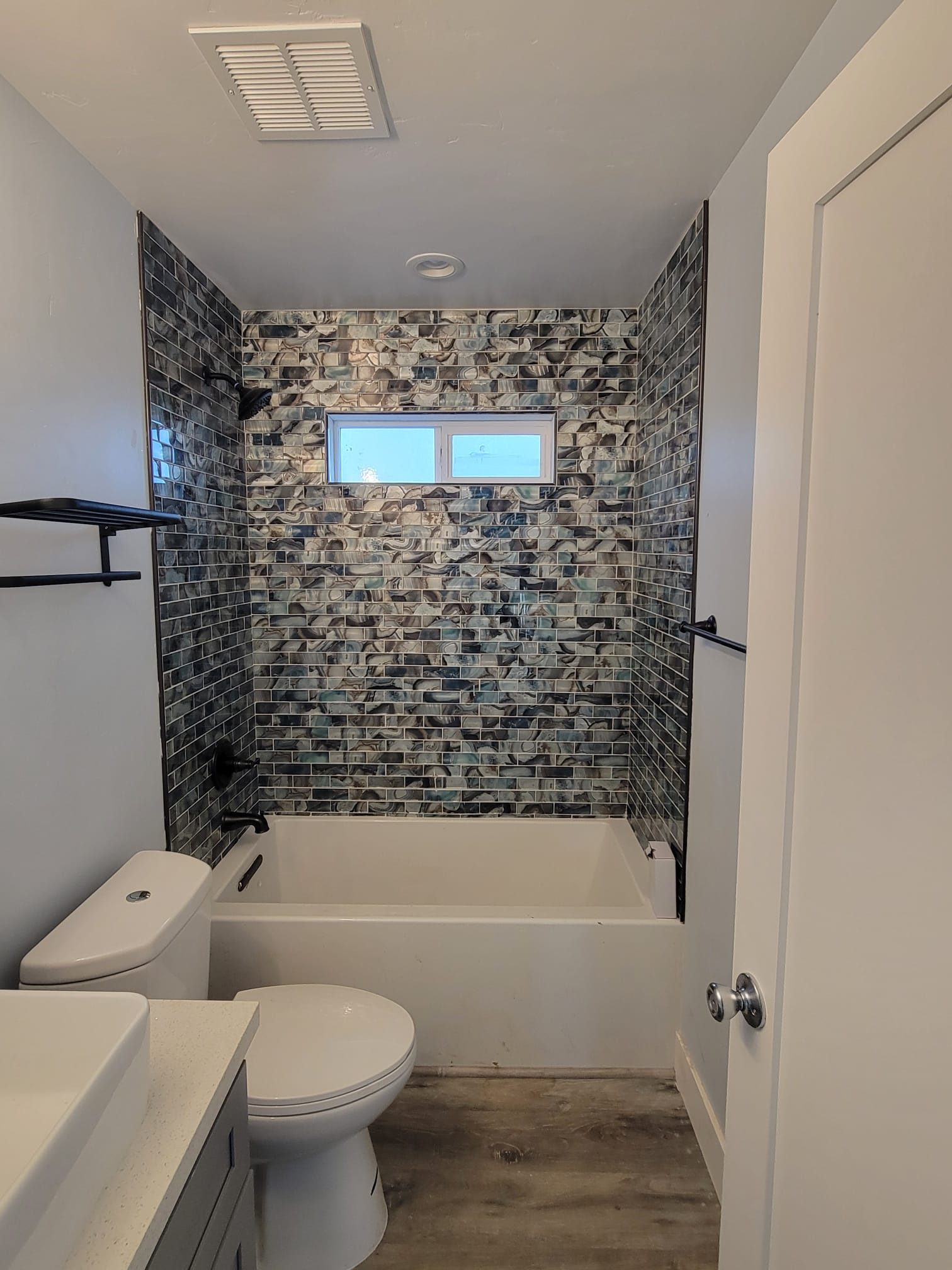 ADU bathroom with mosaic tile tub surround