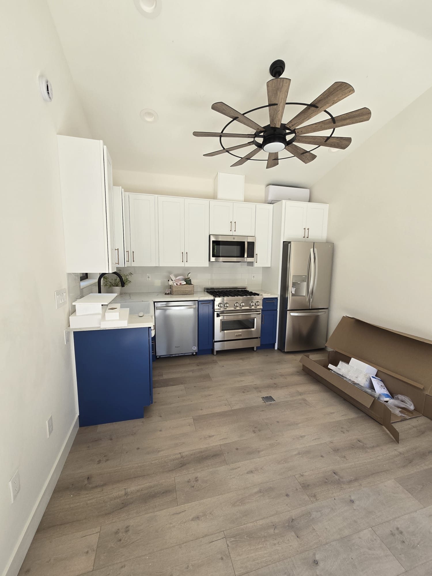 ADU kitchen with white cabinets and windmill-style ceiling fan