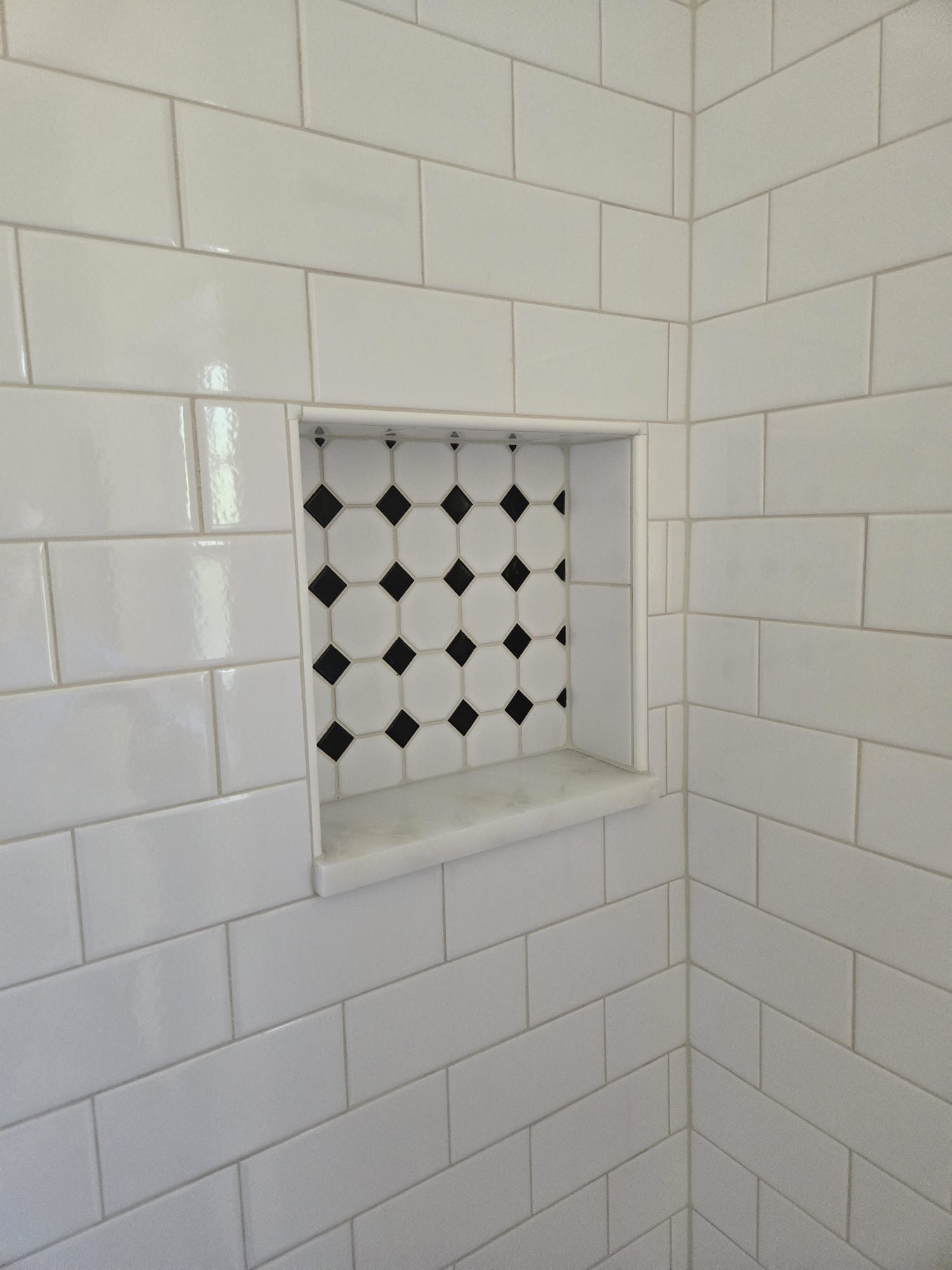 ADU bathroom shower niche with tile inset