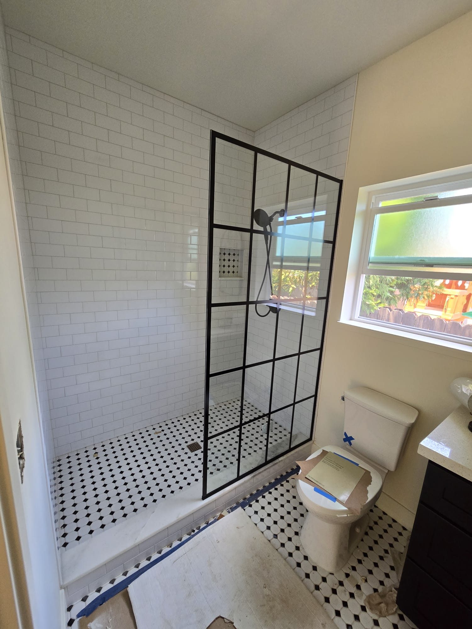 ADU bathroom with black-framed glass shower, alternate angle