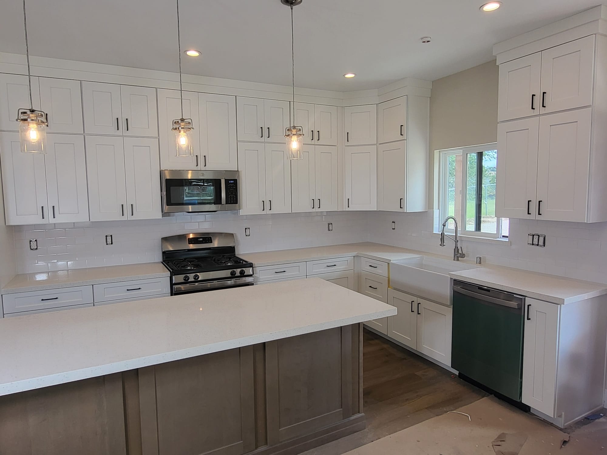 White kitchen with a natural wood island and edison-bulb pendant lighting