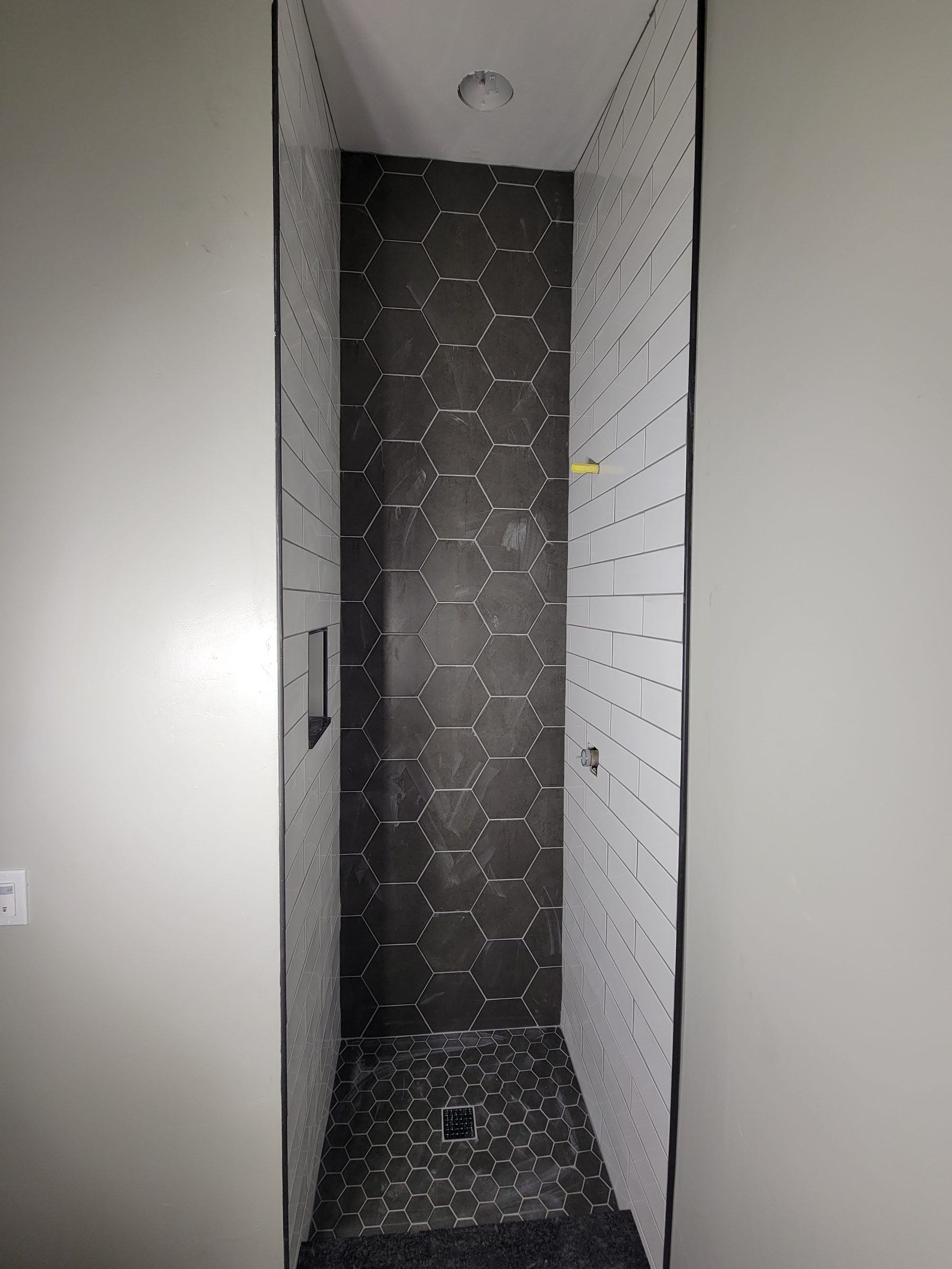 Modern ADU shower with hexagon tile accent wall