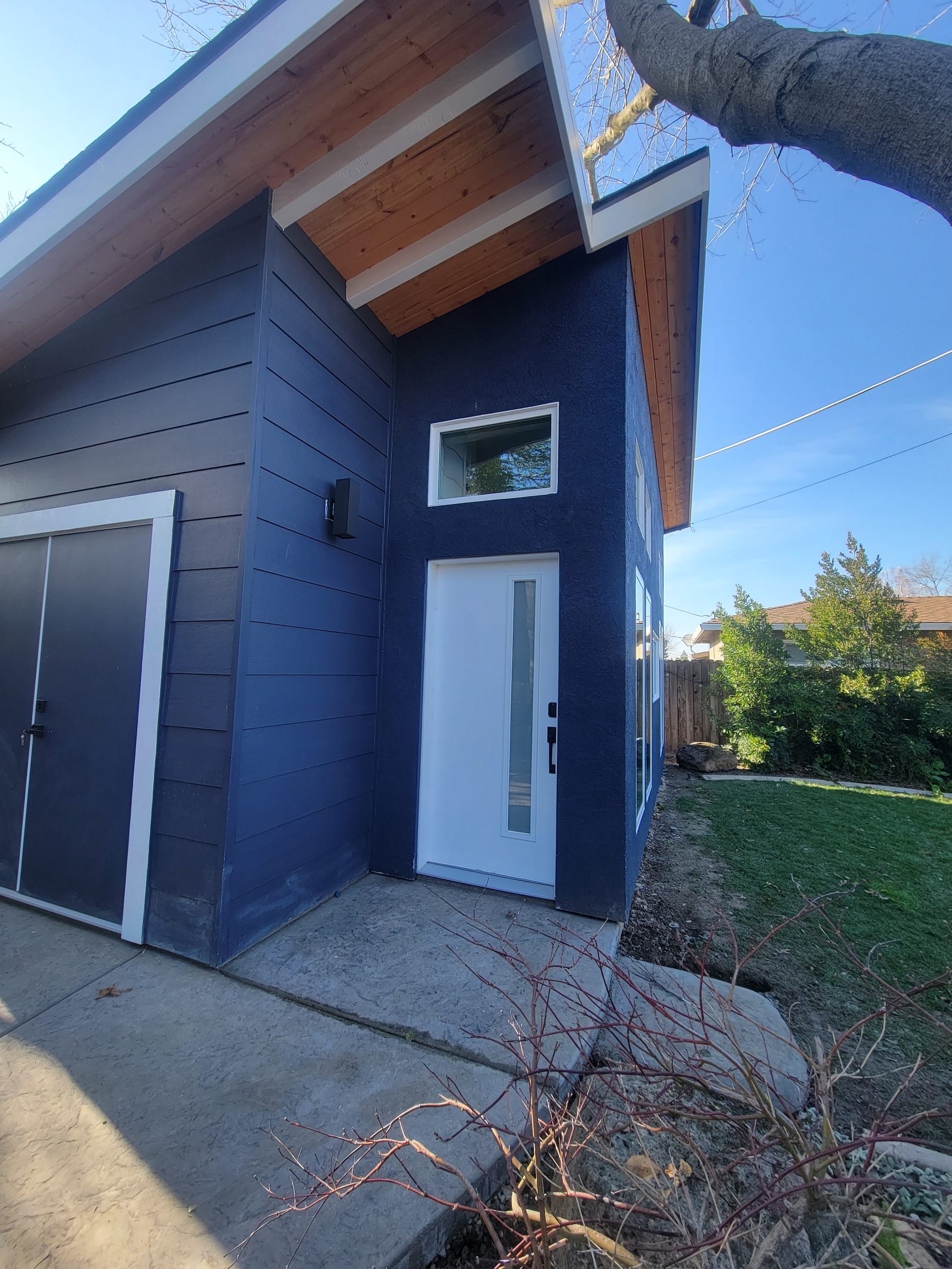 Modern ADU exterior, wide angle showing entry and windows