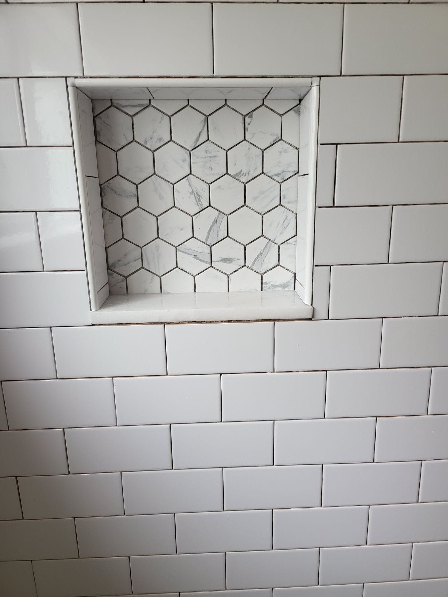 ADU bathroom shower niche with hexagon tile
