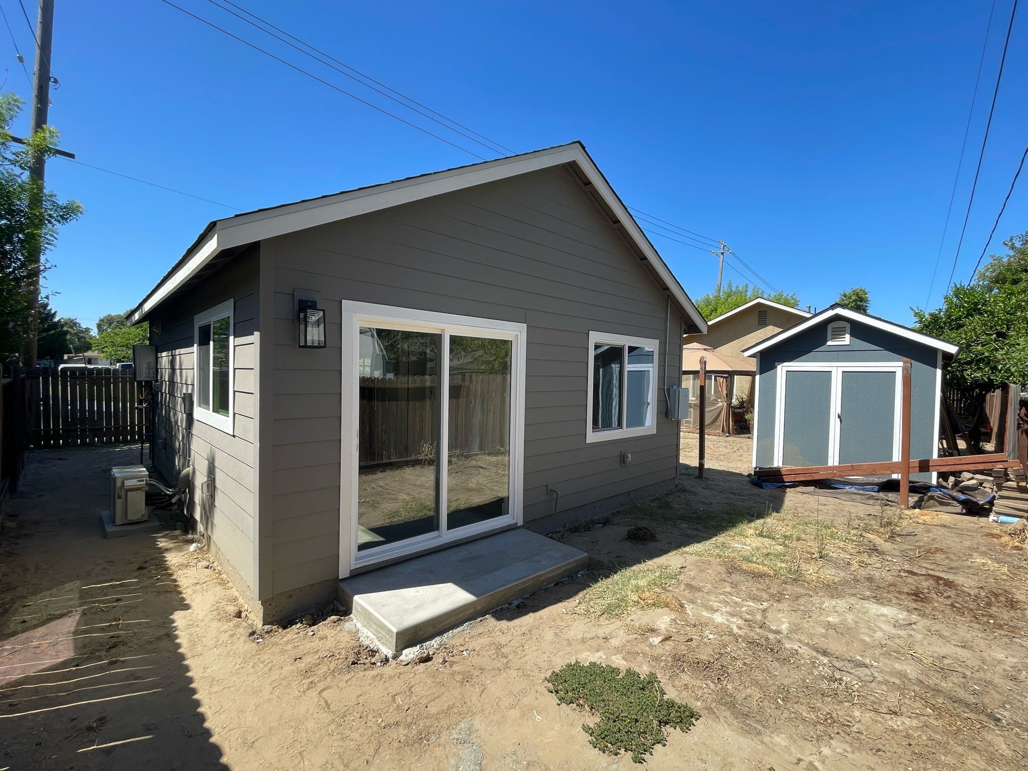ADU exterior with storage shed in yard