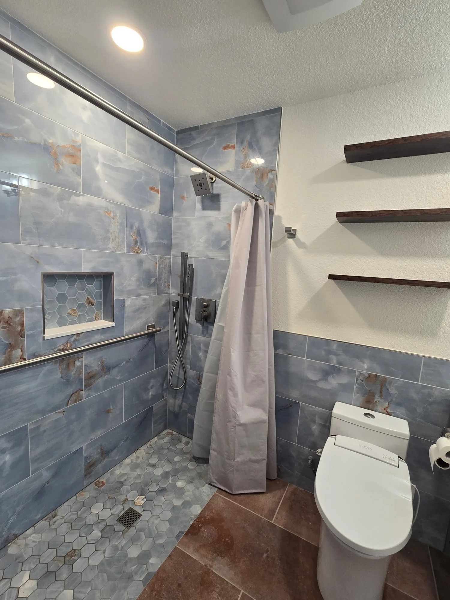 Roll-in shower with grab bars, handheld shower and recessed niche
