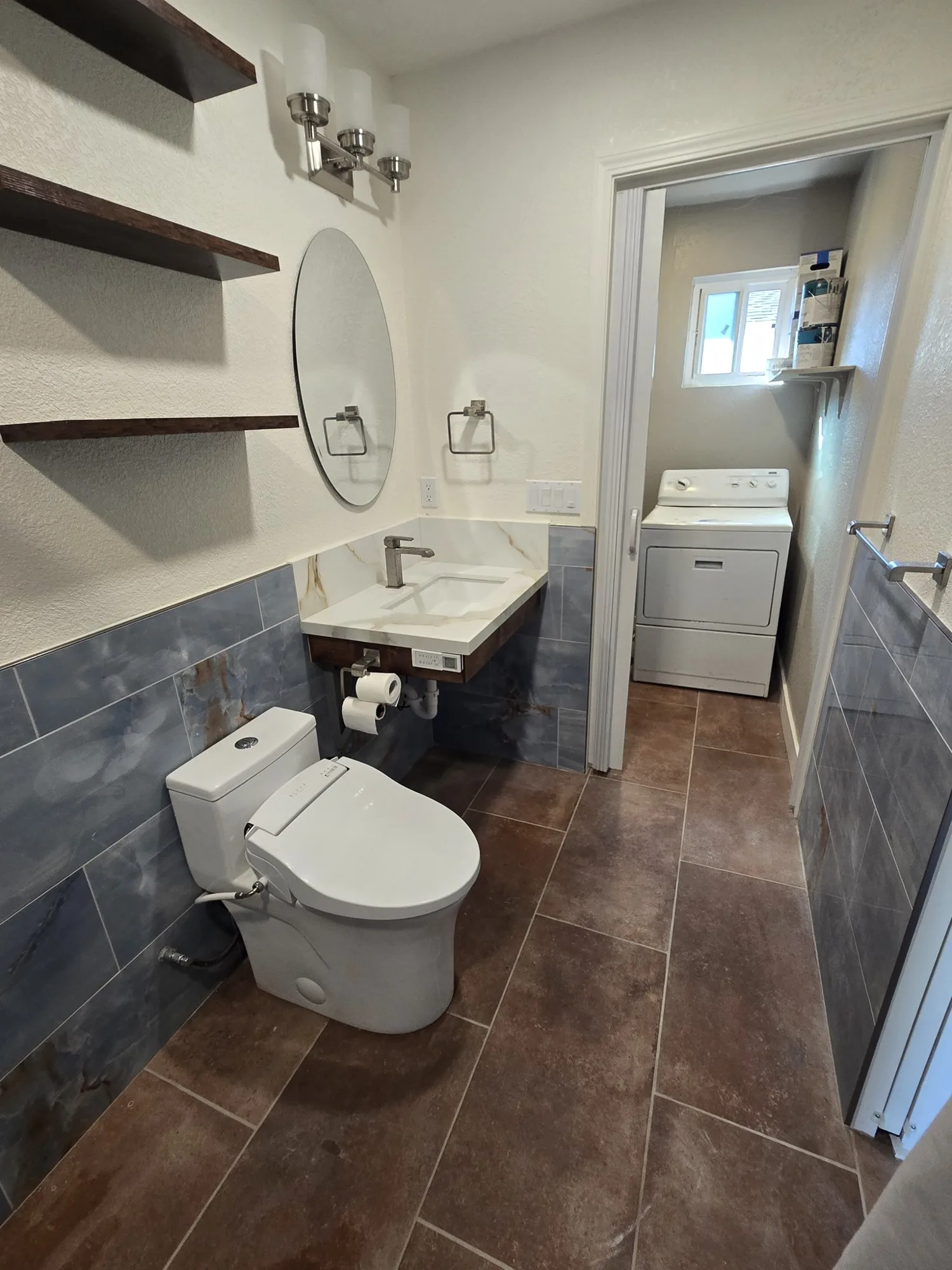 Floating vanity and shelves with a doorway through to the laundry room