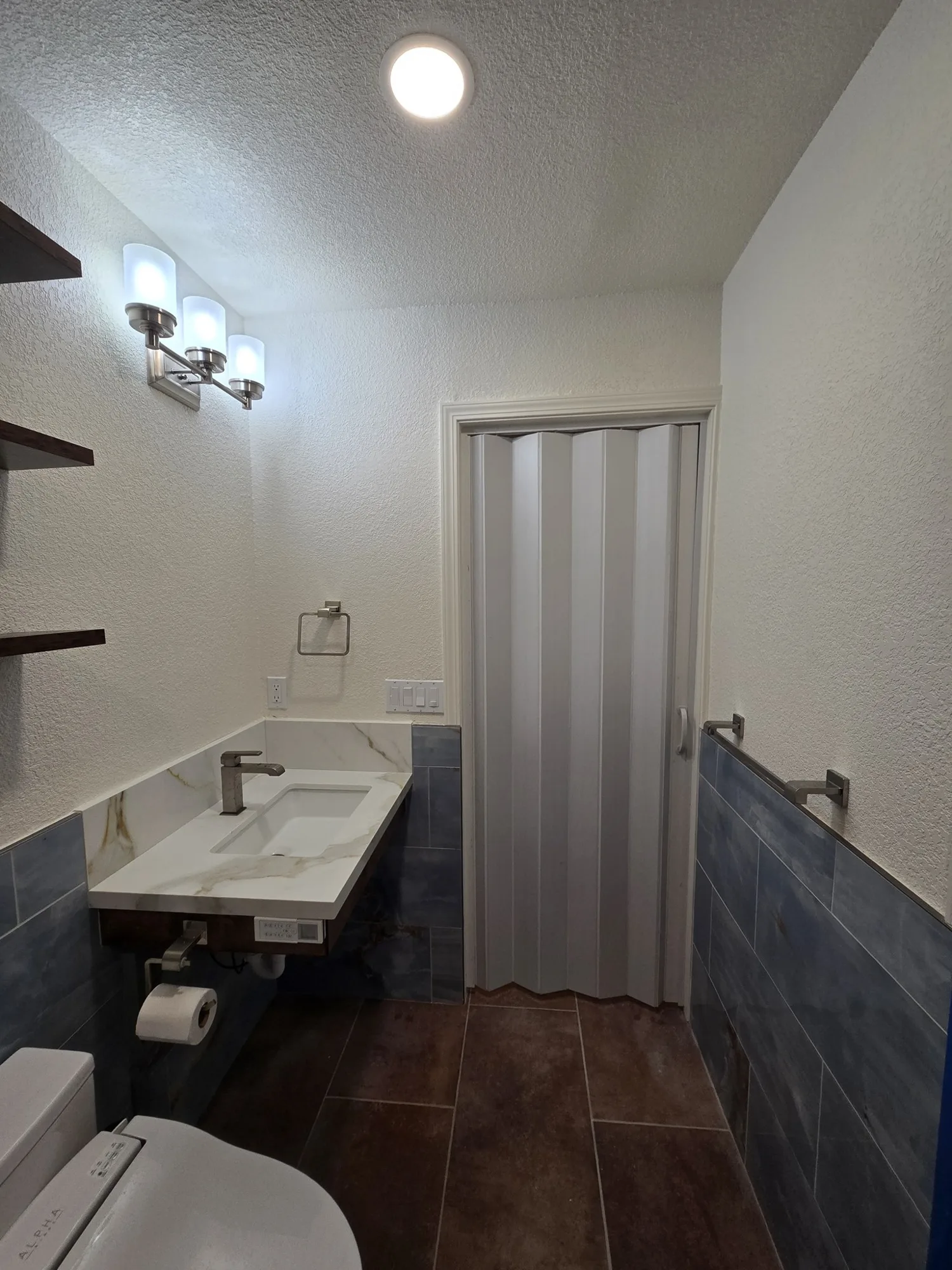 Floating sink beside a new accordion-style door