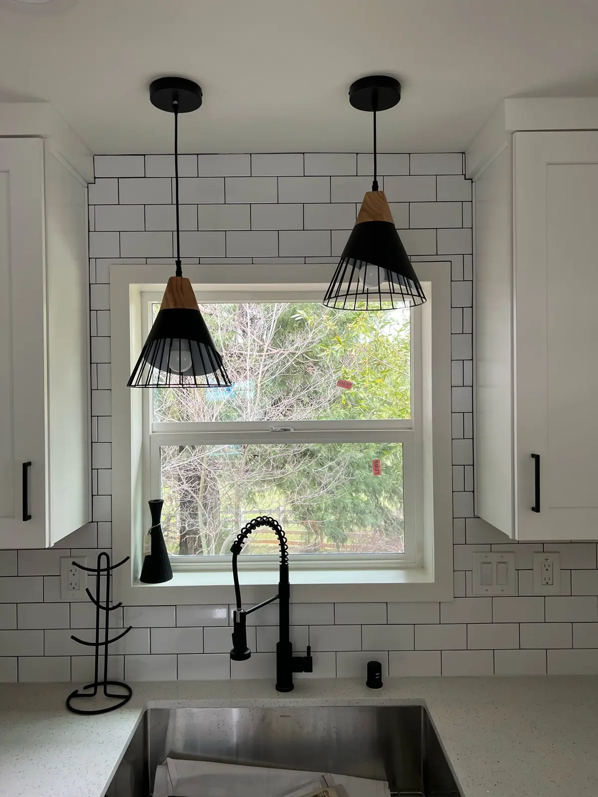 Finished compact ADU kitchen with white cabinets and black fixtures
