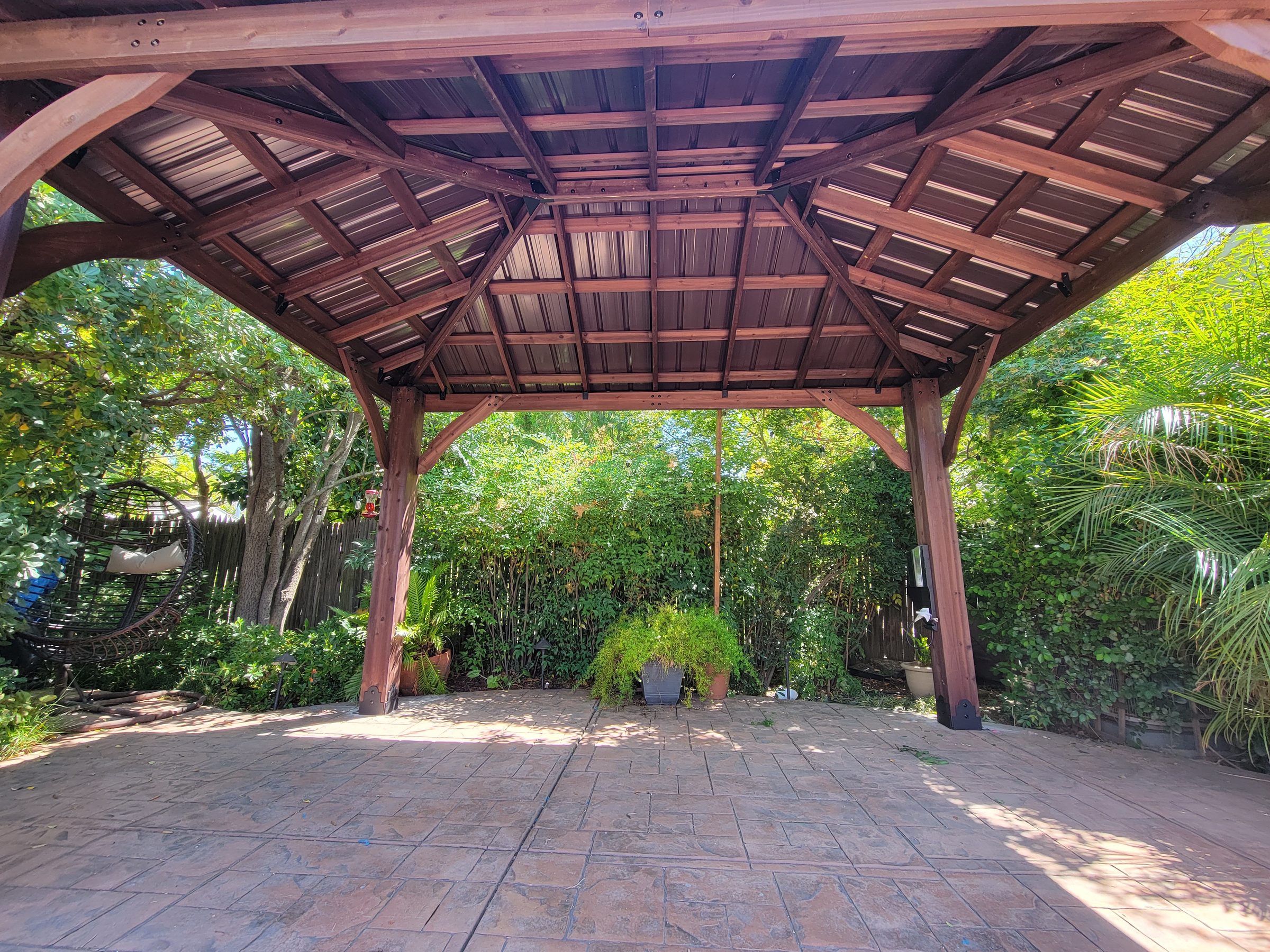 Underside of the gazebo roof showing exposed rafters and curved knee braces
