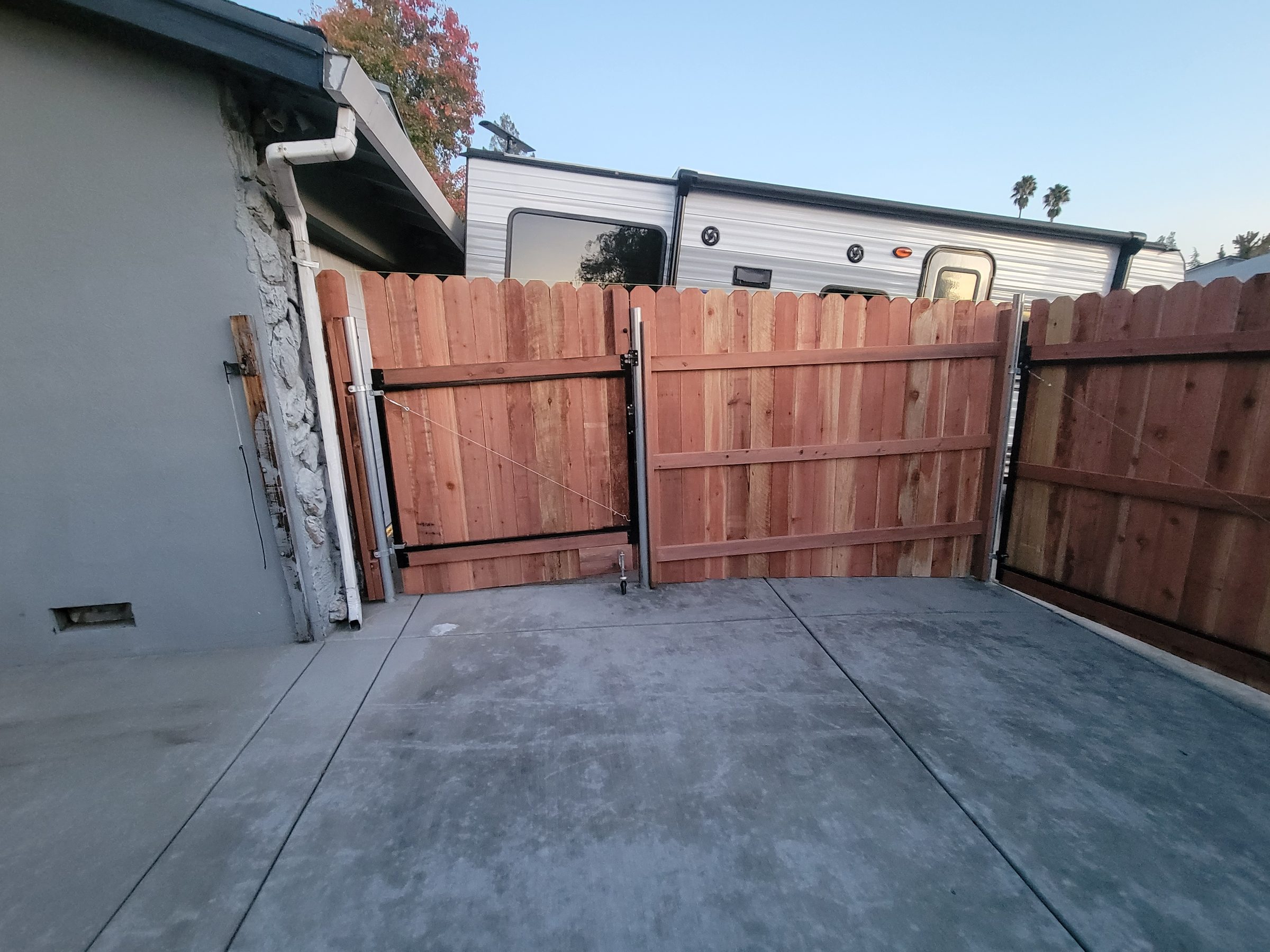 New wood gate with steel posts beside the house