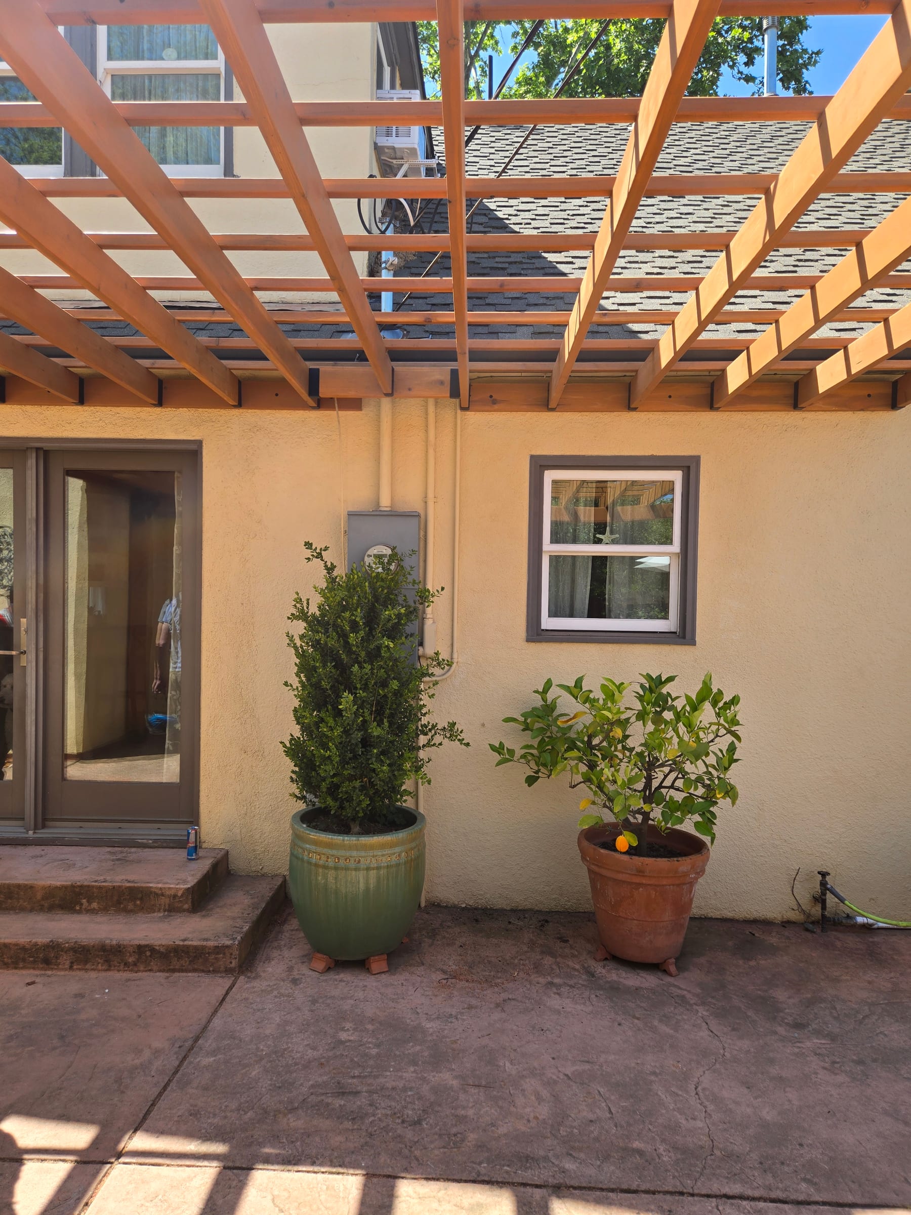 Underside view of the finished pergola lattice against the roofline