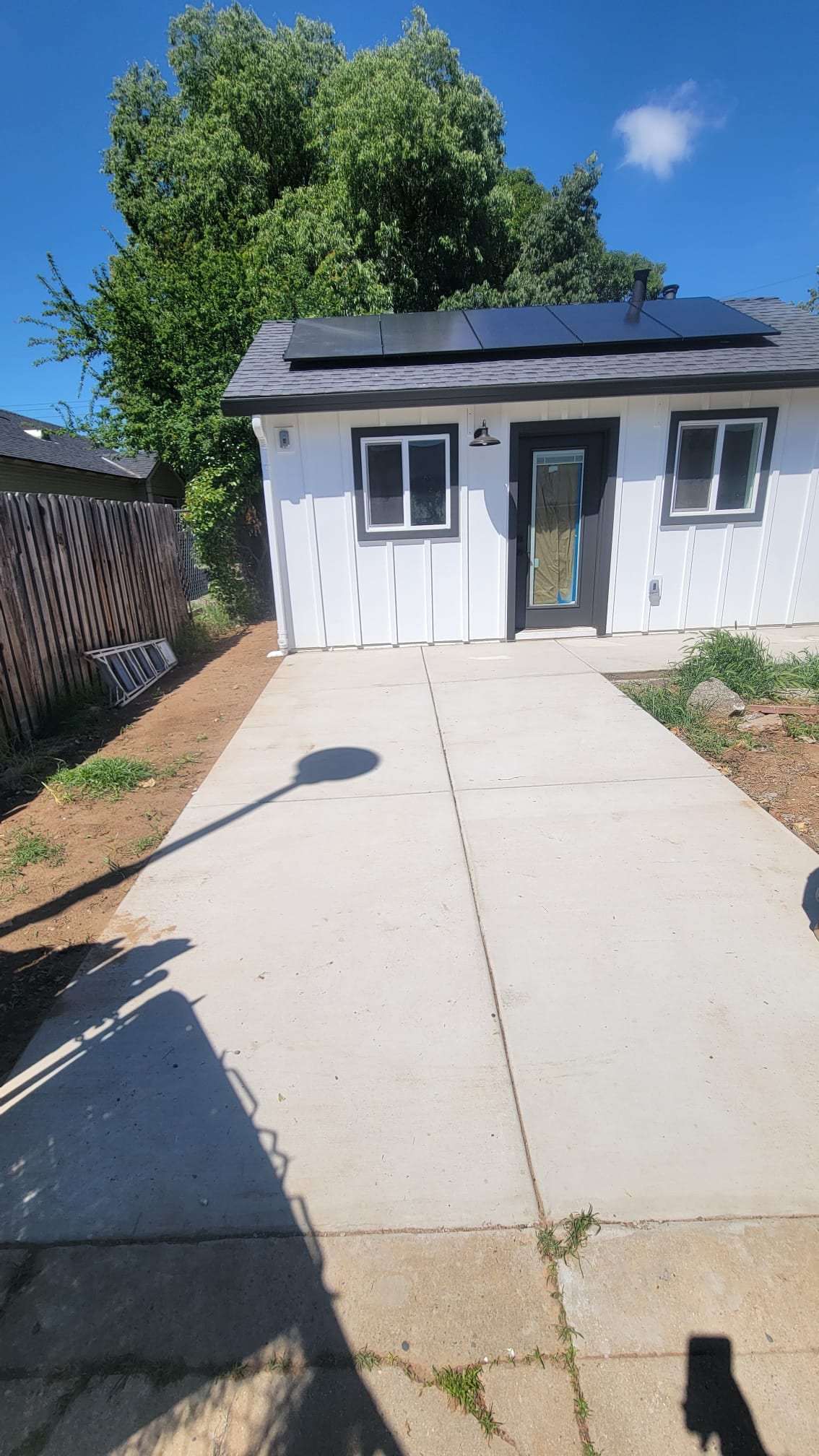 East Sac ADU exterior, side view with new concrete walkway and solar panels