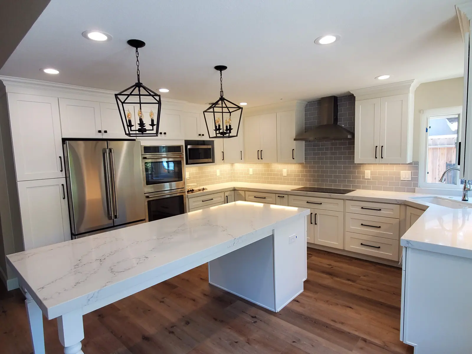 Detailed view of finished white cabinetry, counters, and appliances