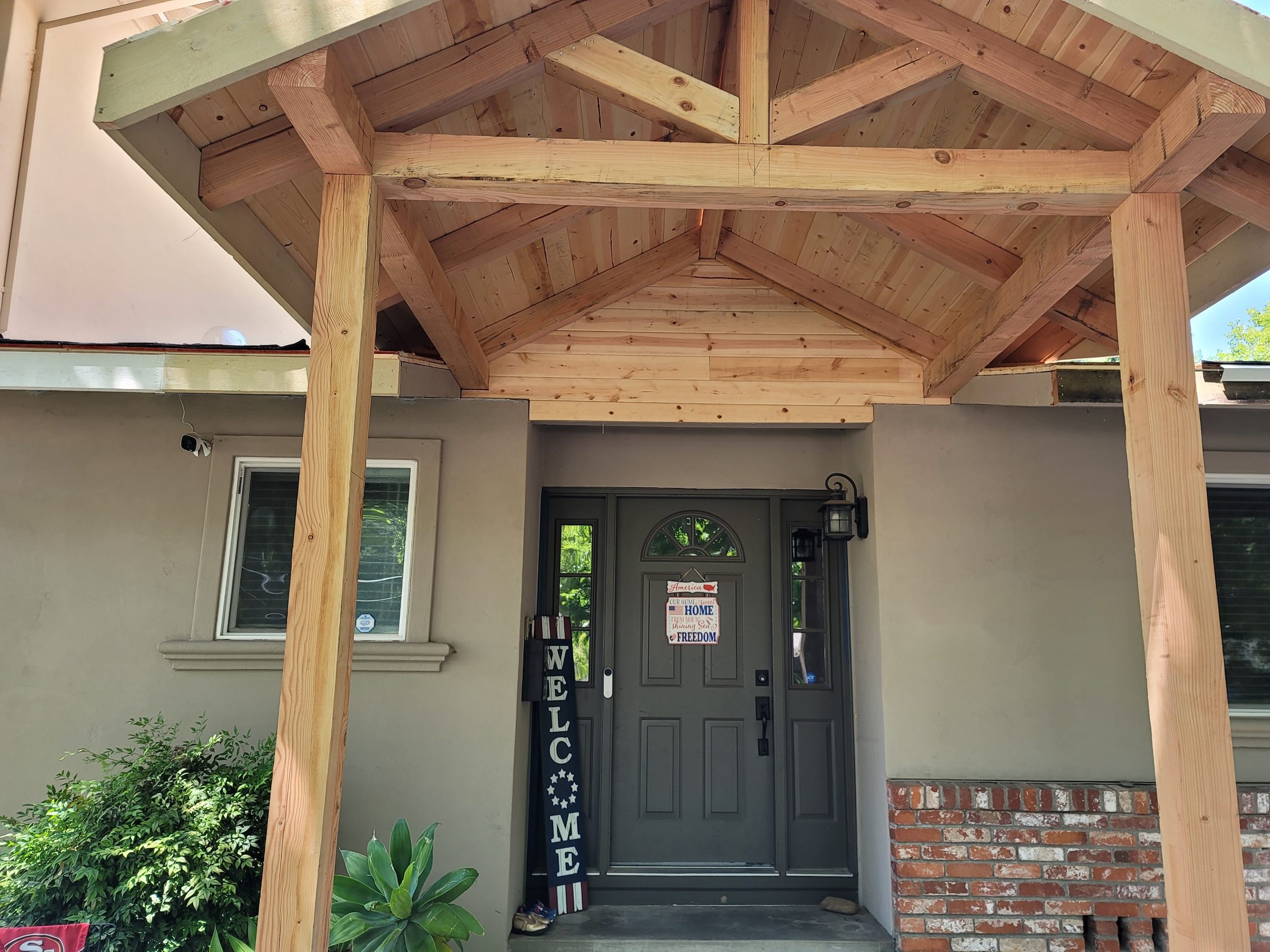 Wood post-and-beam gabled porch framing over the front door