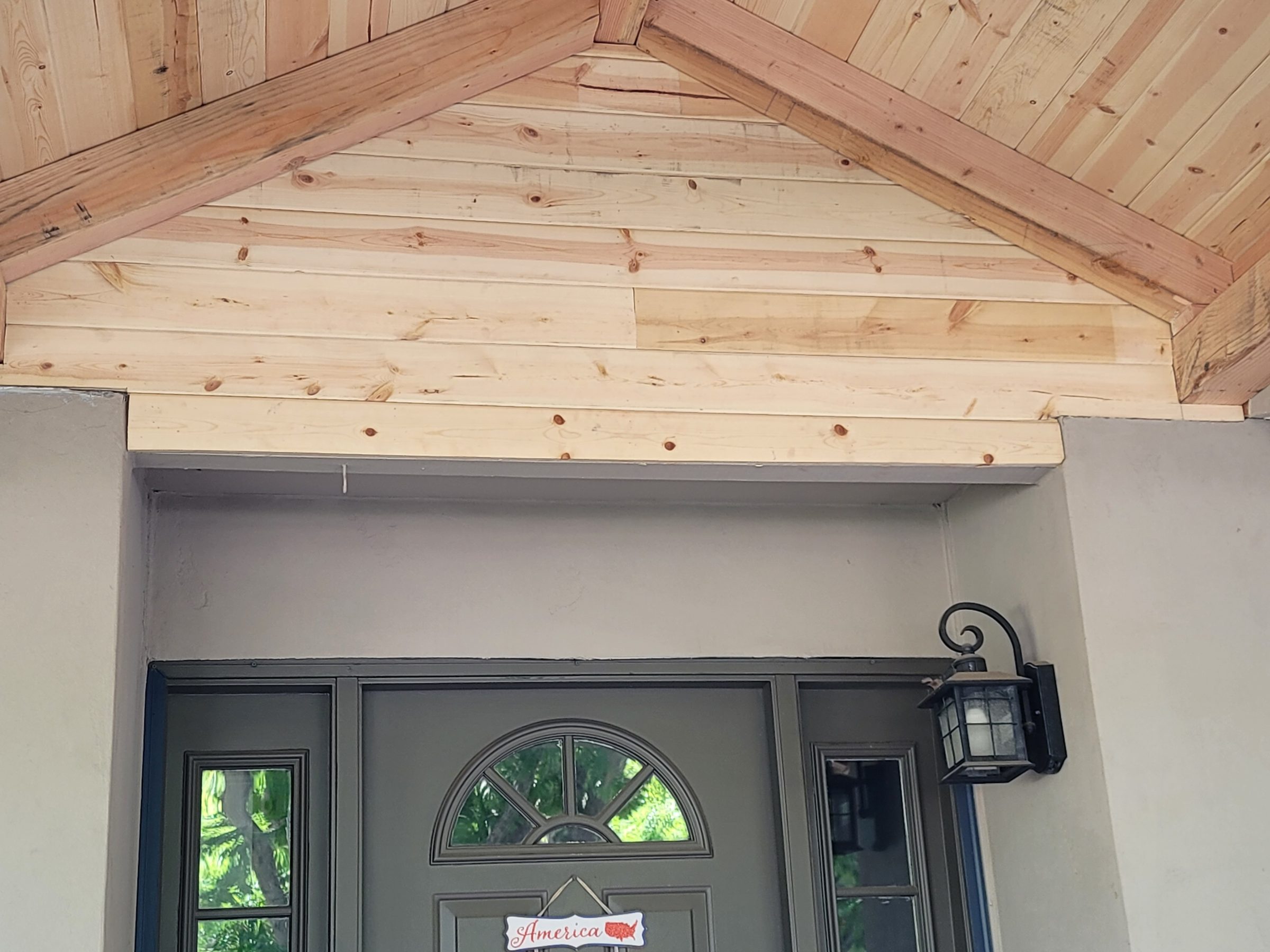 Detail of the porch ceiling: tongue-and-groove boards and exposed gable framing
