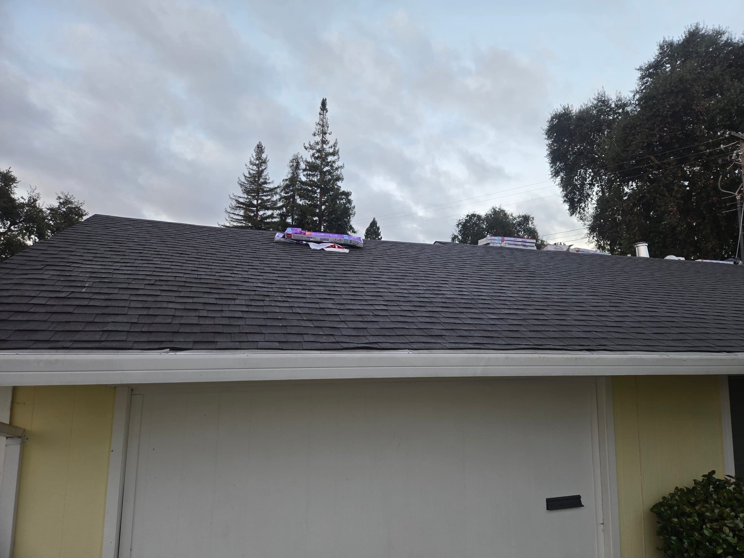 Close view of the new composition shingle field along the roof ridge