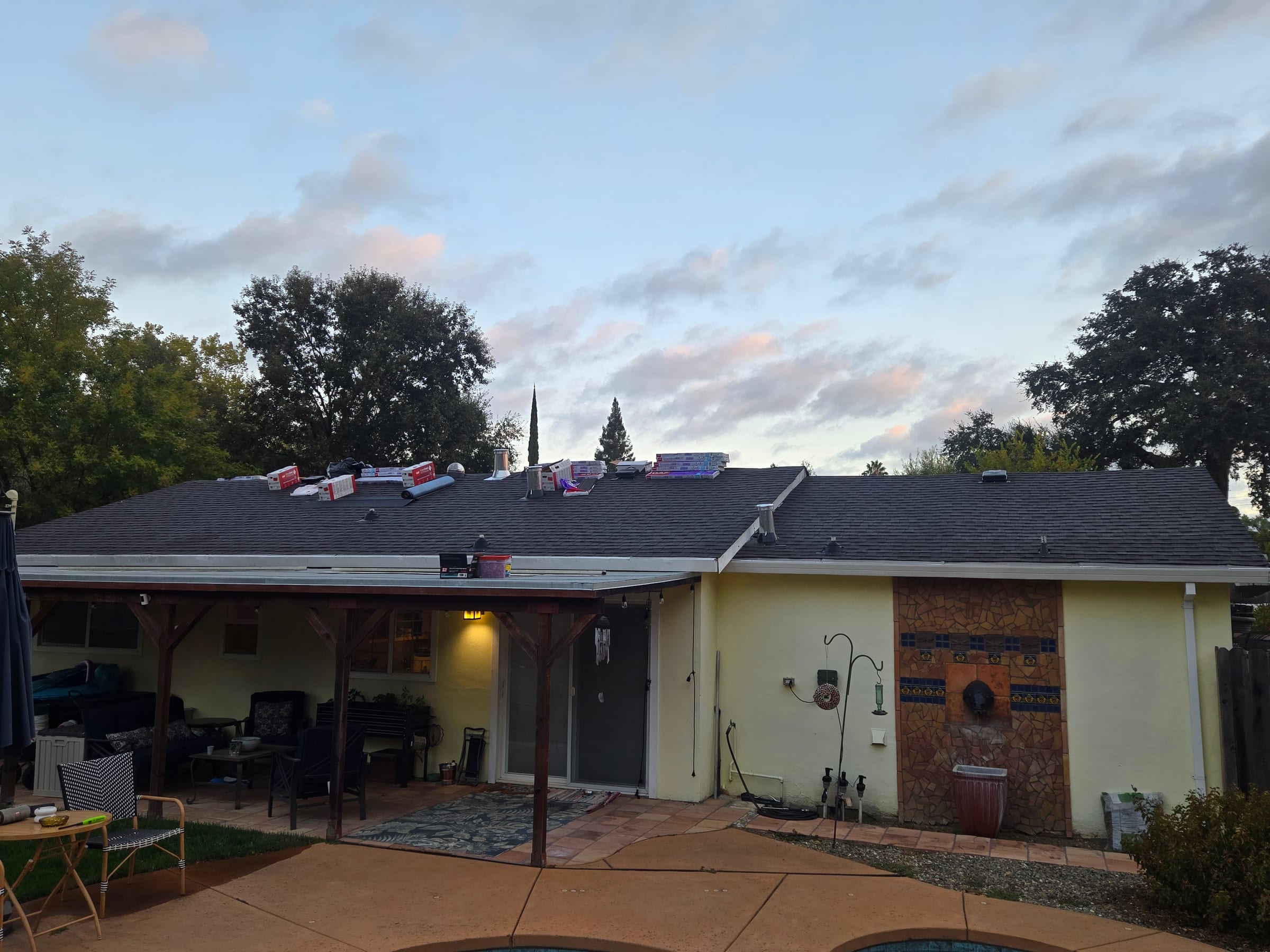 Wide view of the completed shingle roof over the back patio and pool area