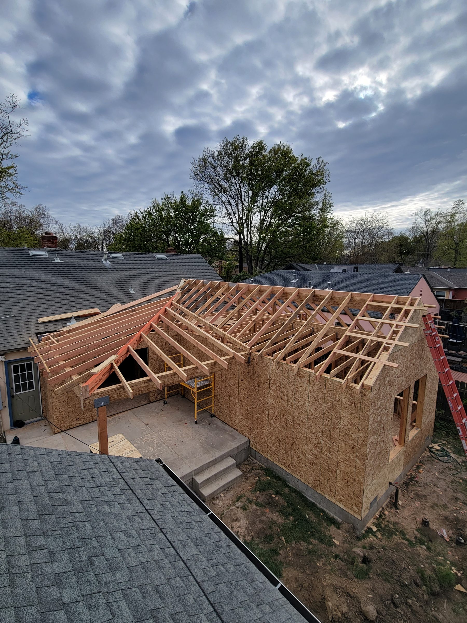 Aerial view of addition walls and roof rafters going up