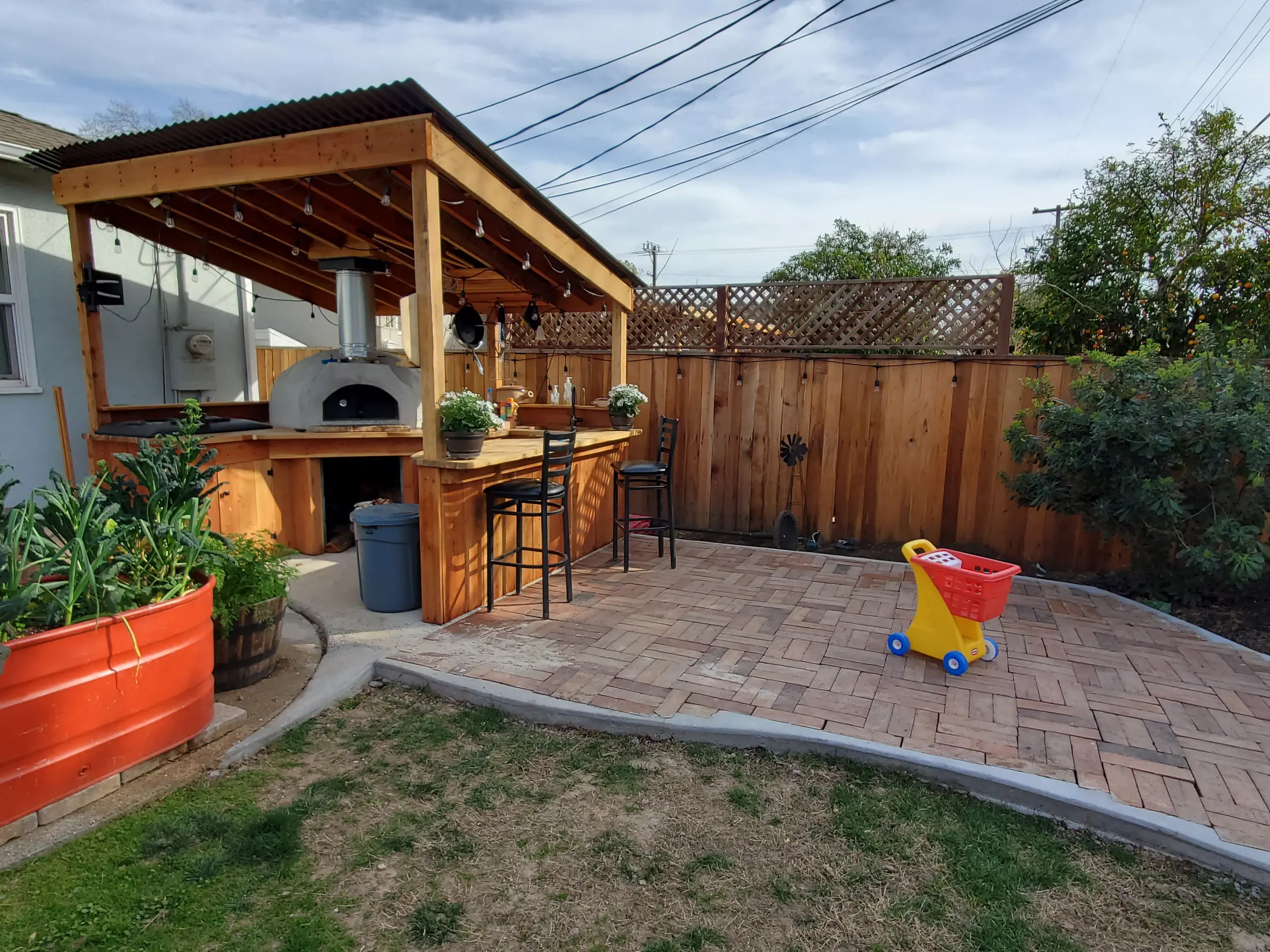 Wide view of the completed outdoor kitchen and brick gathering patio