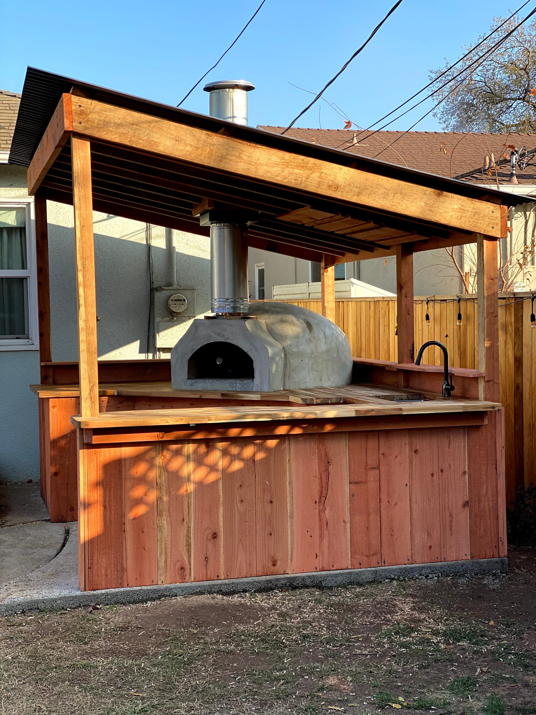Outdoor kitchen and pizza oven, straight-on view showing the full covered structure