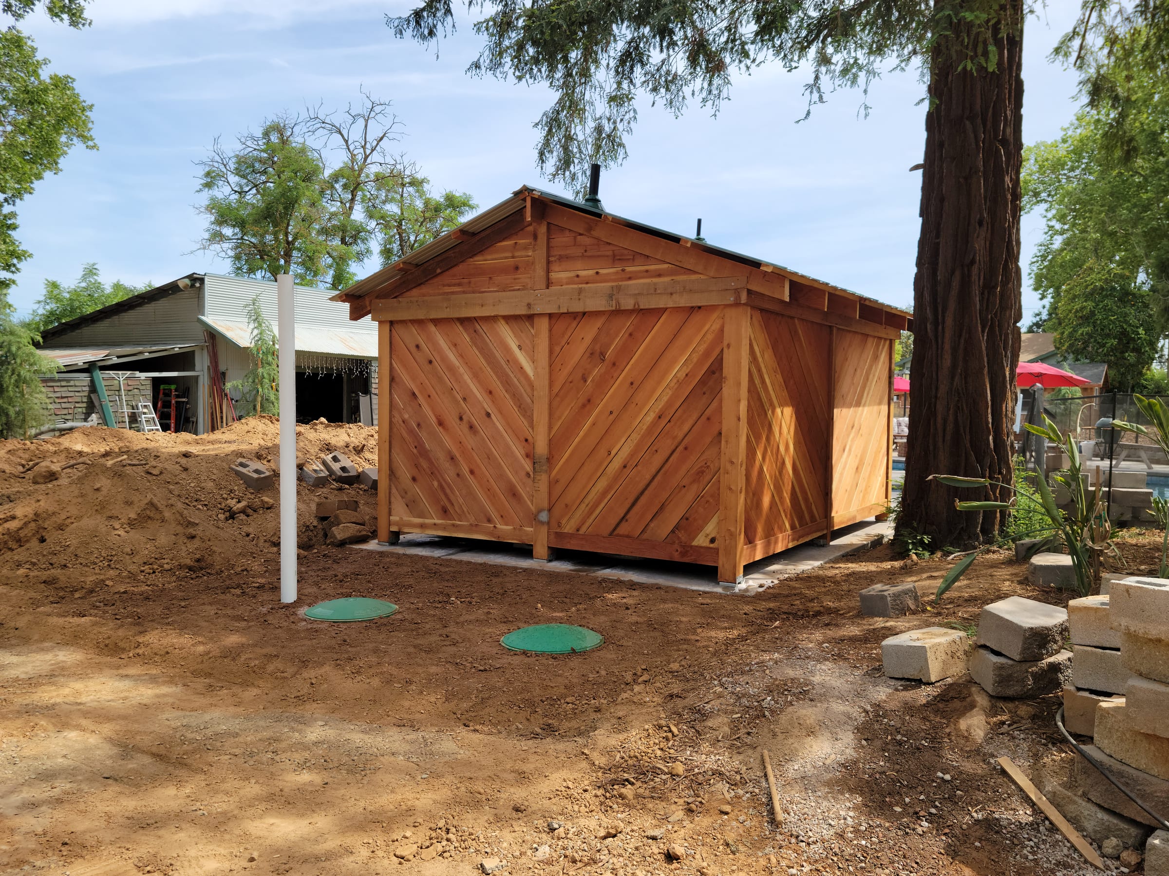 Finished pool bathroom with septic tank access lids in the yard