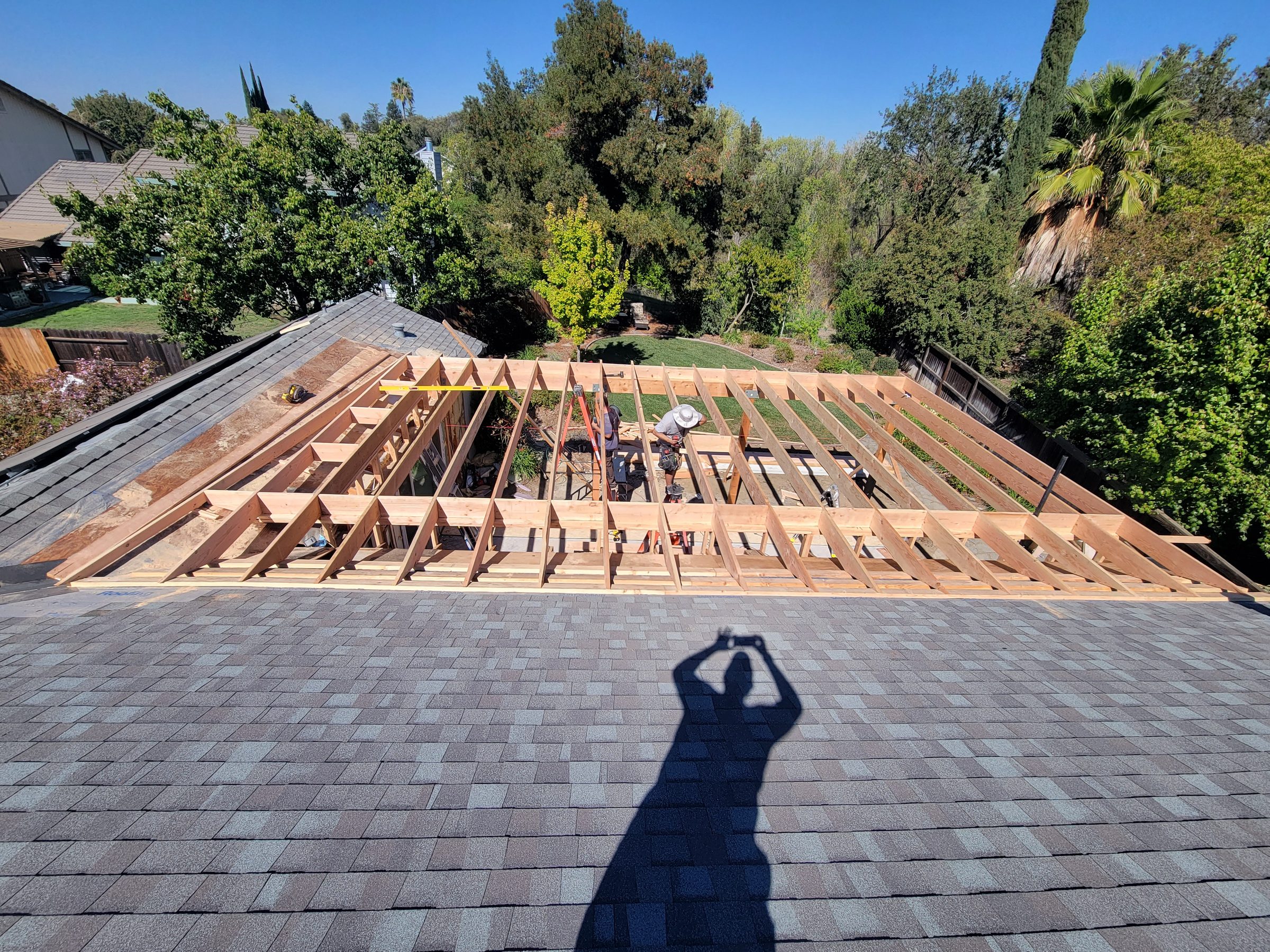 Overhead view of new roof joists being framed over an existing roof