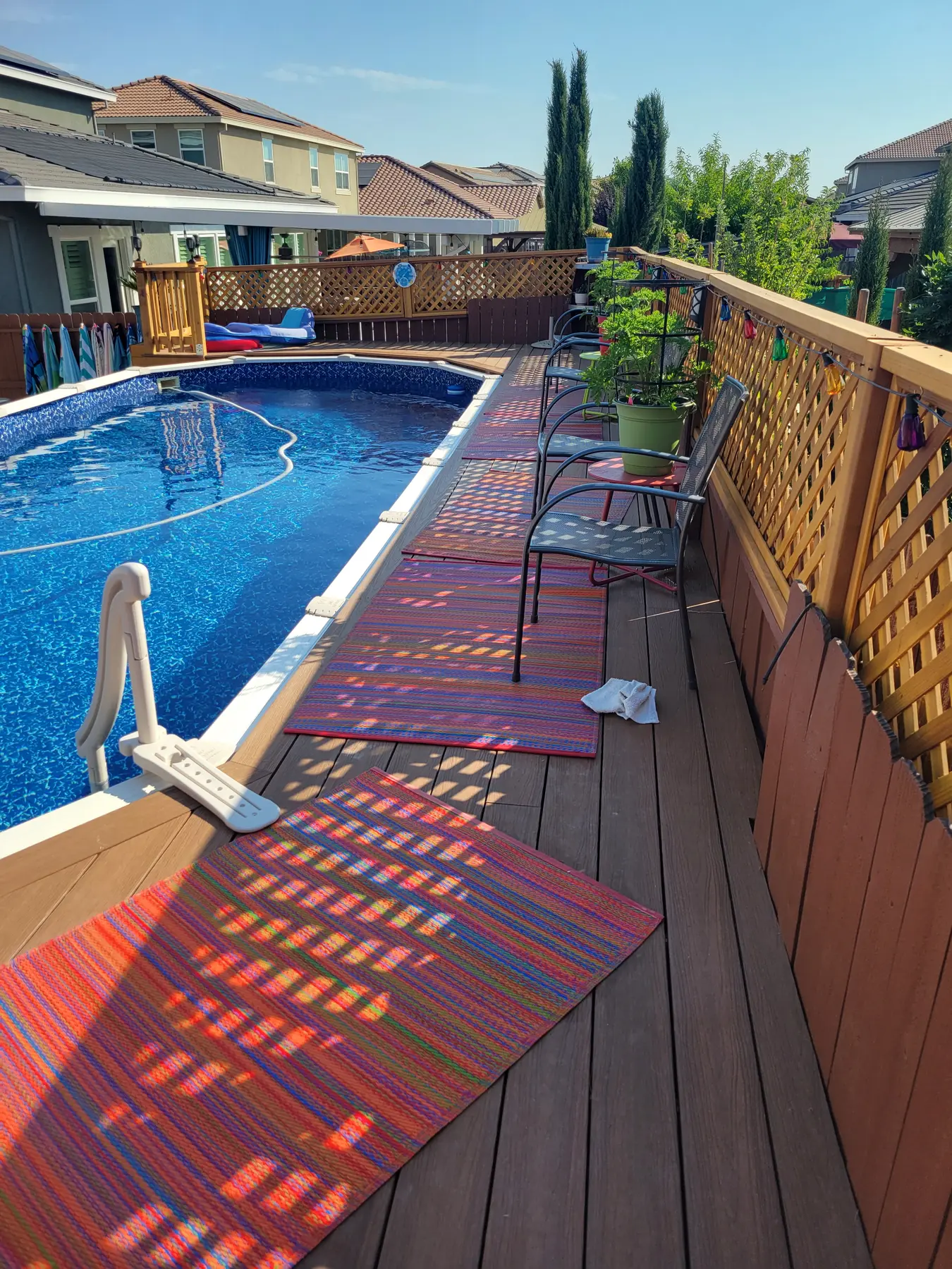 Completed red poolside deck with coordinated railing in Roseville